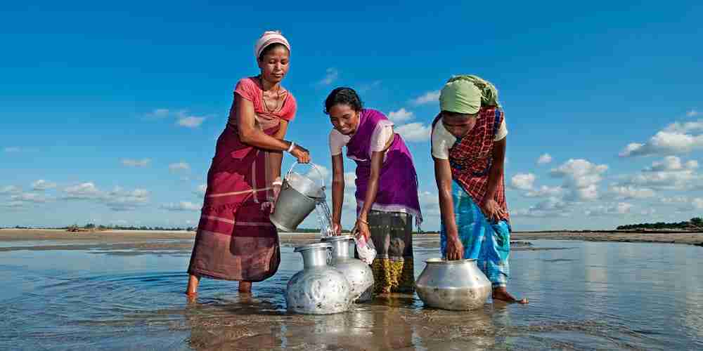 Women filling up their jars with dirty water