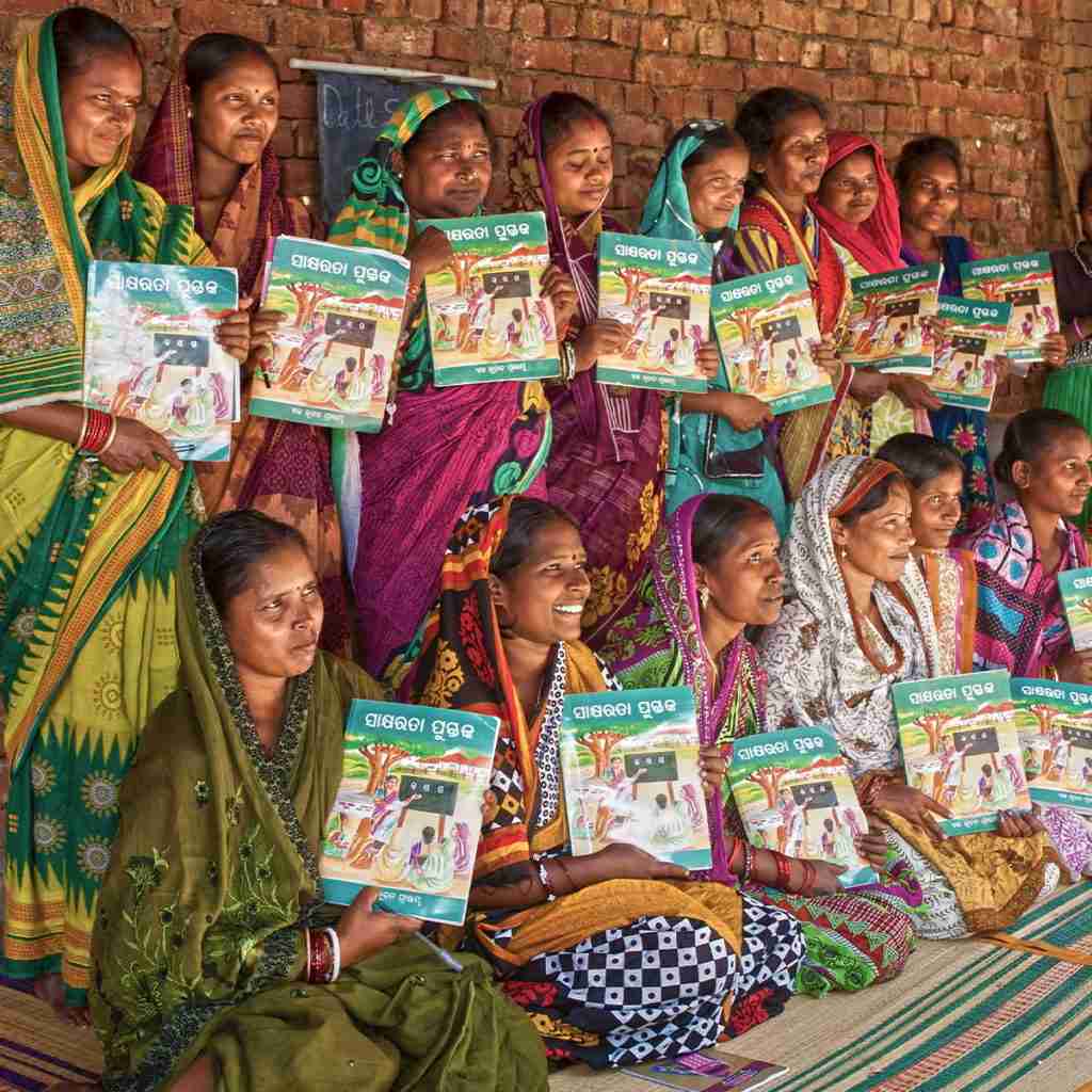 Women holding their free literacy books as they ended the day's adult literacy class