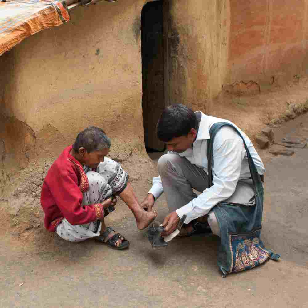 National missionary worker helping a leprosy patient in poverty