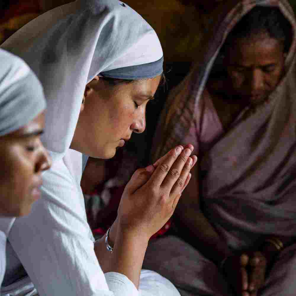 GFA World women missionaries praying for a widow