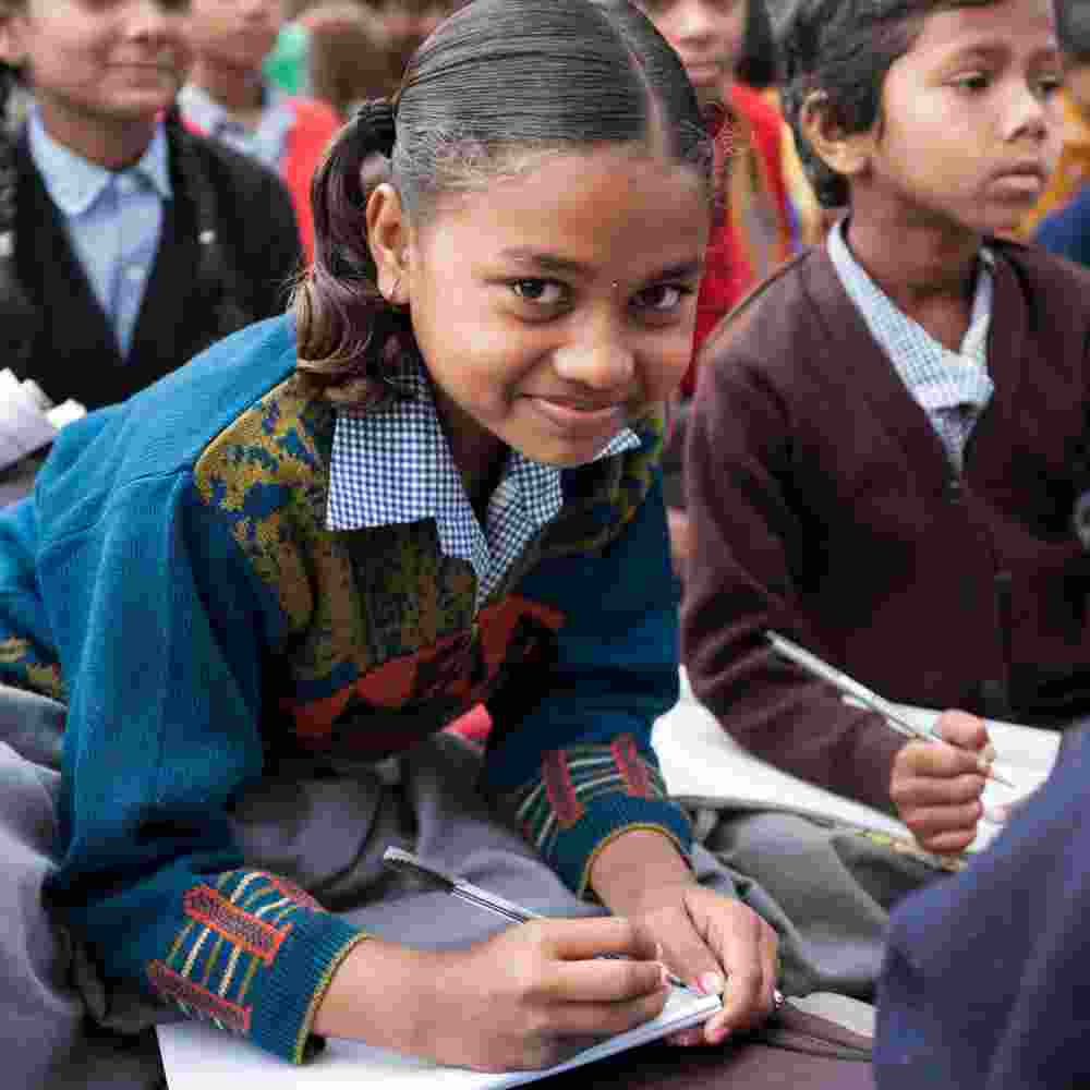 GFA World child sponsorship program Bridge of Hope girl student writes notes in class