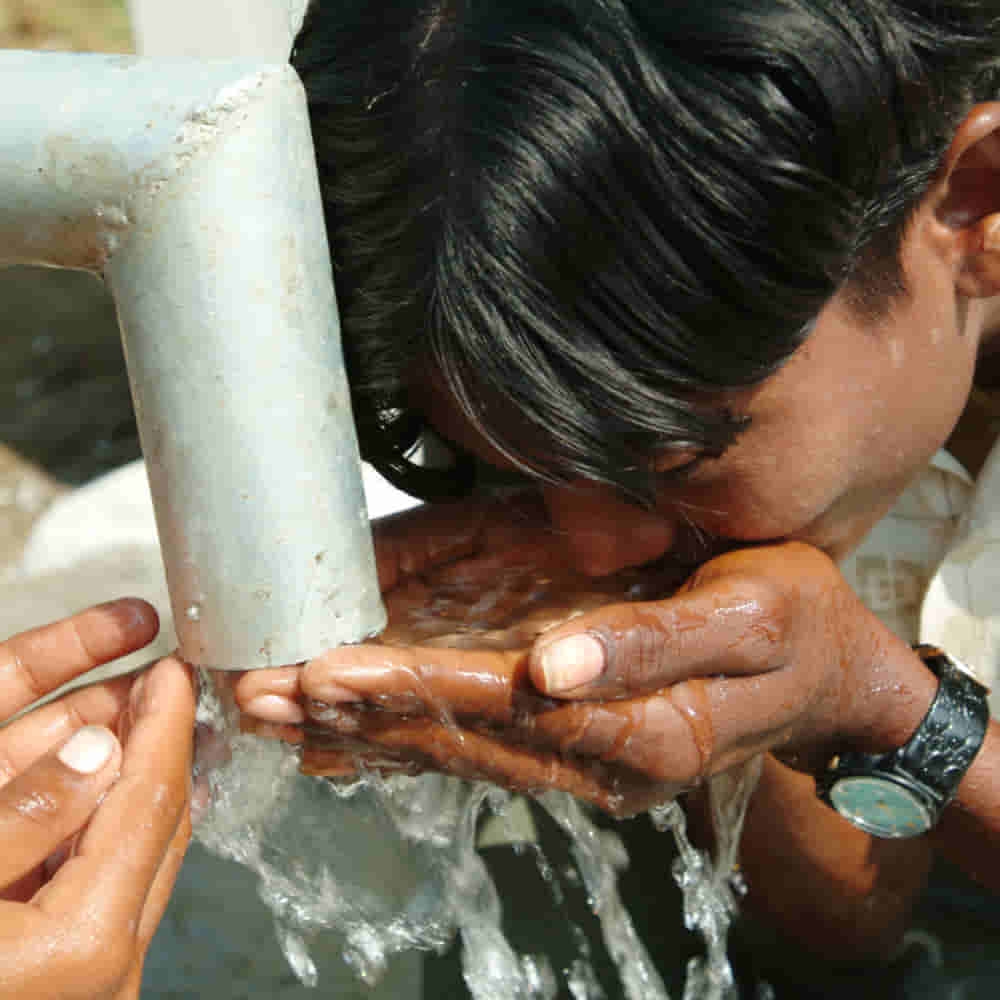 Man drinks clean water from GFA World Jesus Wells