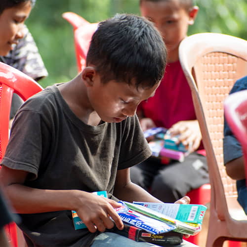 Young boy receives school supplies from GFA World gift distribution