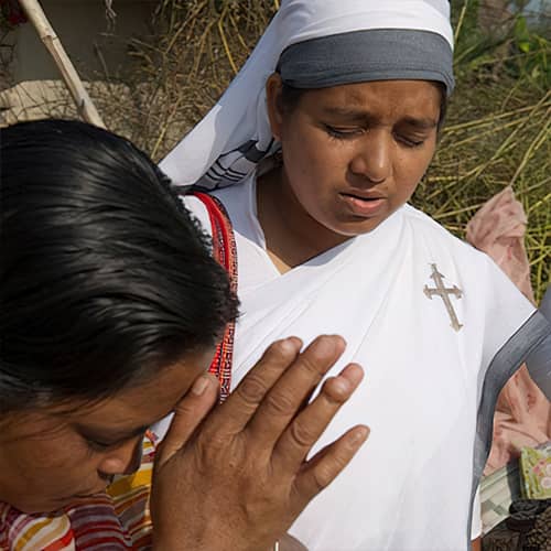 GFA World woman missionary praying for a widow