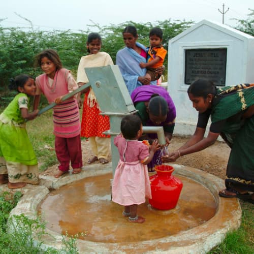Family draws clean water from GFA World (Gospel for Asia) Jesus Wells