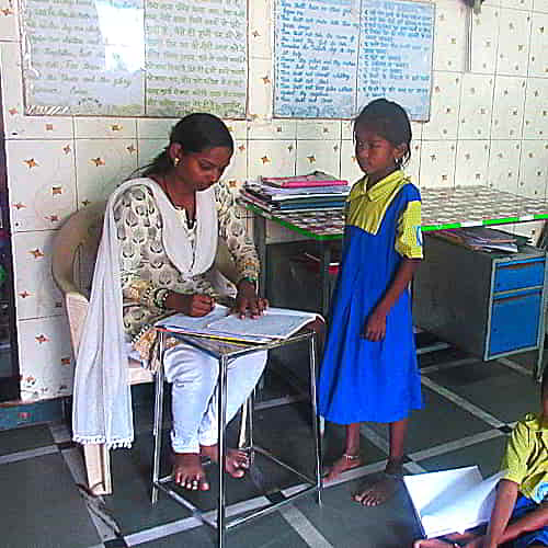 Kasni receiving instruction from her teacher at GFA World child sponsorship program