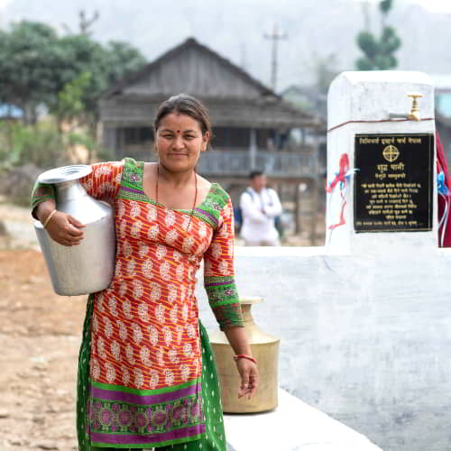 Woman collects clean water through Jesus Wells provided by GFA World, a clean water charity