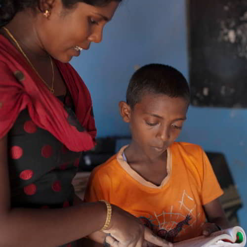 Teacher instructs a young boy in a child sponsorship program by GFA World, one of the organizations that help poverty in South Asia