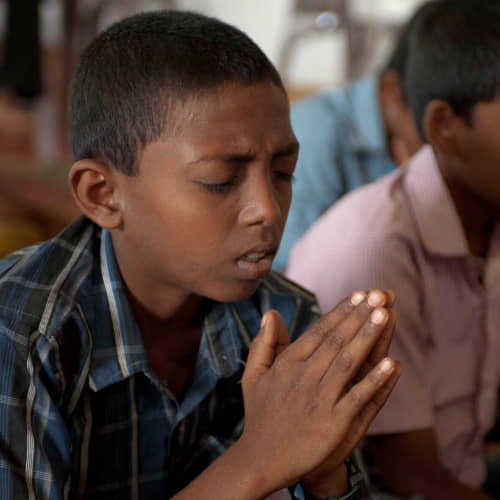 Young boy praying in GFA World child sponsorship program