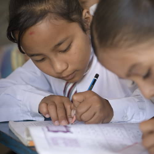 Children writing on their notebooks in GFA World child sponsorship class