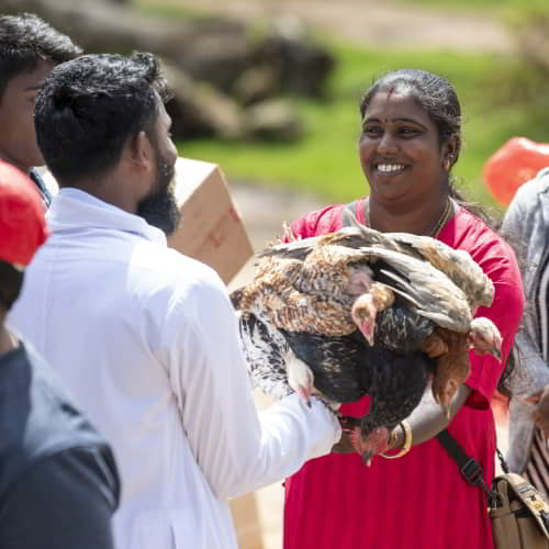 Woman received income generating gift of a pair of chickens through GFA World gift distribution
