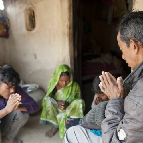 GFA World national missionary praying for a family in poverty