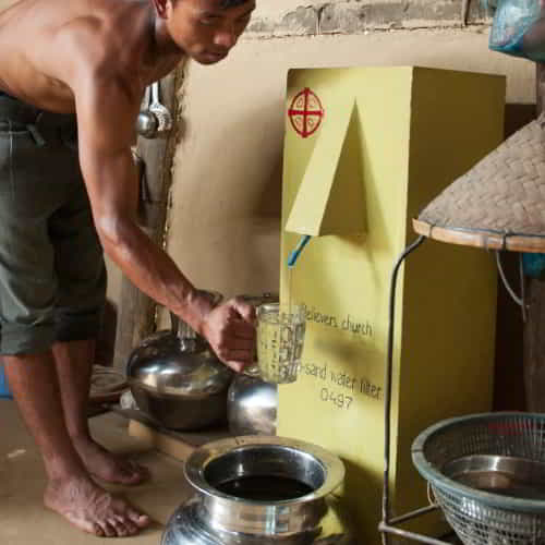 Man collects clean water through GFA World BioSand Water Filter