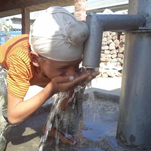 Young boy drinks clean water through GFA World Jesus Wells