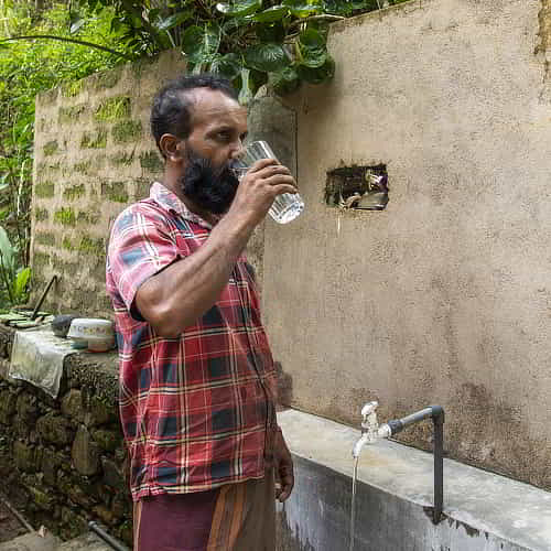 Man drinks clean water through GFA World Jesus Wells