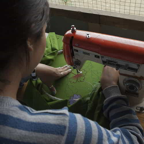 Woman learning how to sew in GFA World's vocational training program