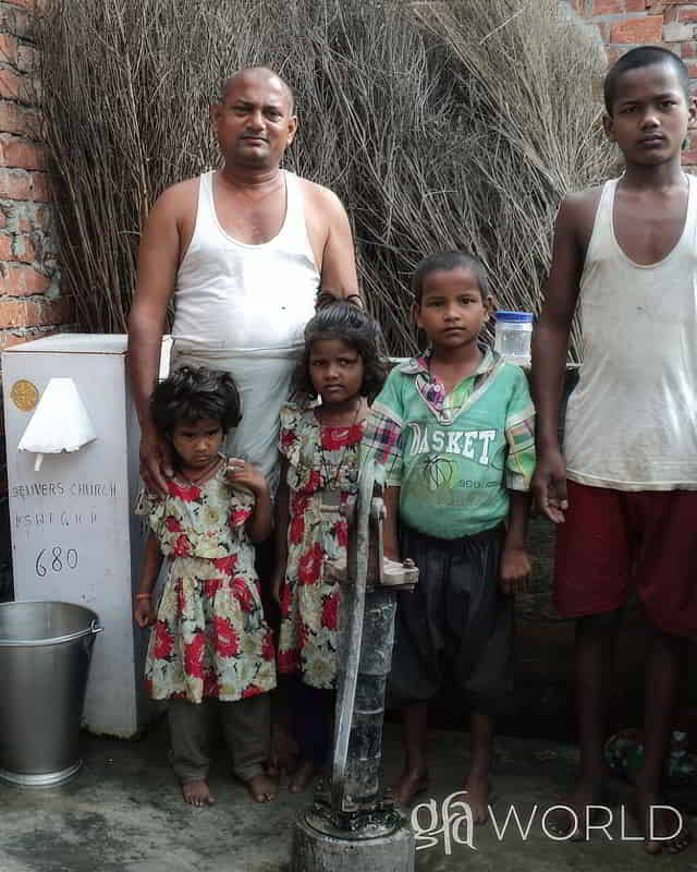 Kaigain and his family enjoy clean water through Biosand water filter through GFA World's Christian missionary activities