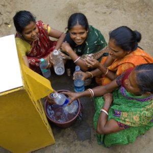 Group of women filling their bottles with clean water from a BioSand water filter