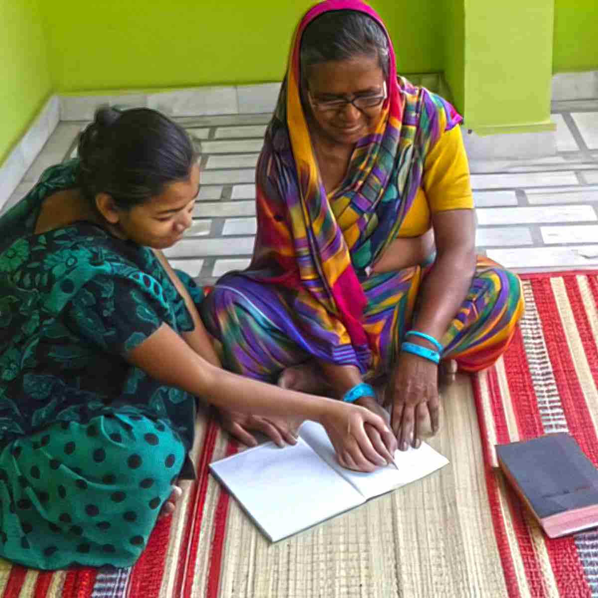 GFA World women missionaries gently guided Jeni (right) as they taught her to read and write.