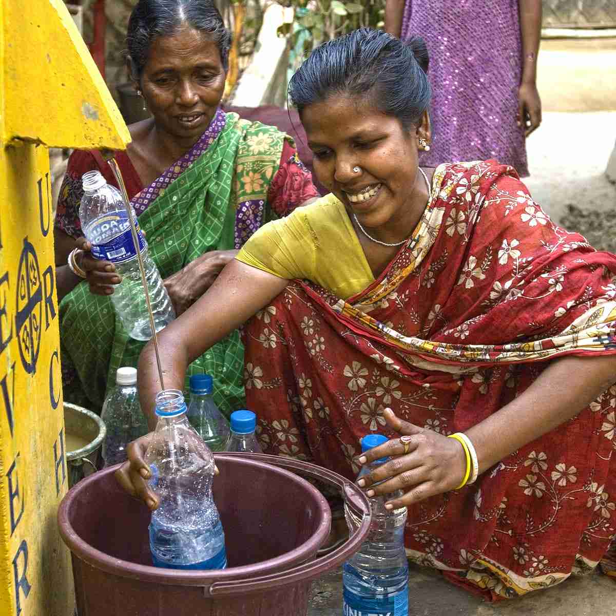 Nimala filling up bottles with clean water from a BioSand water filter