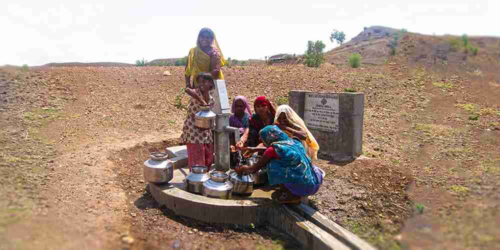 Group of women drawing clean water from a Jesus Well, using one of the types of water wells.