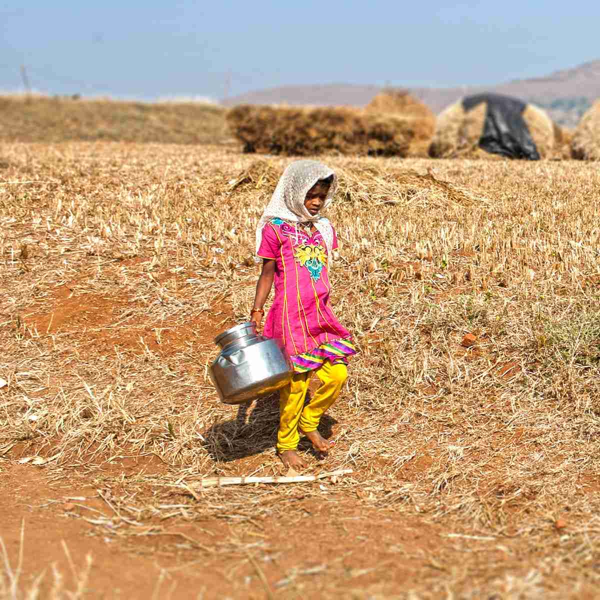 Young girl walking long distances in order to draw water for her family