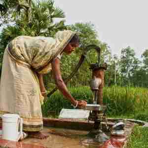 Woman washes her pans with clean water from GFA Jesus Wells