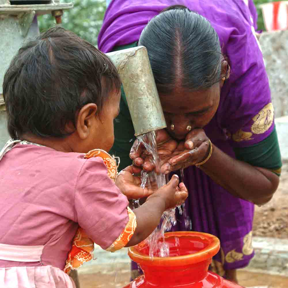 Woman and little girl drinking clean water from GFA World Jesus Wells