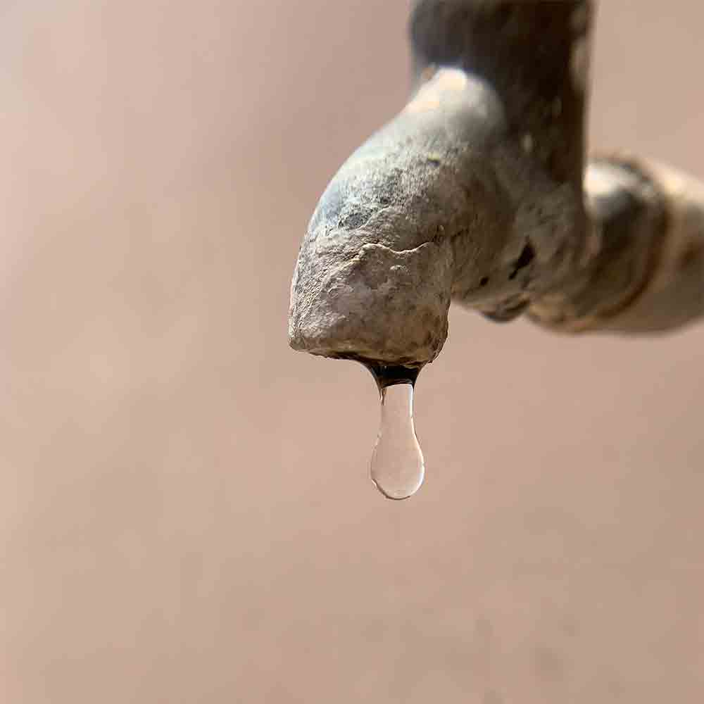 A faucet in the midst of water stress drought