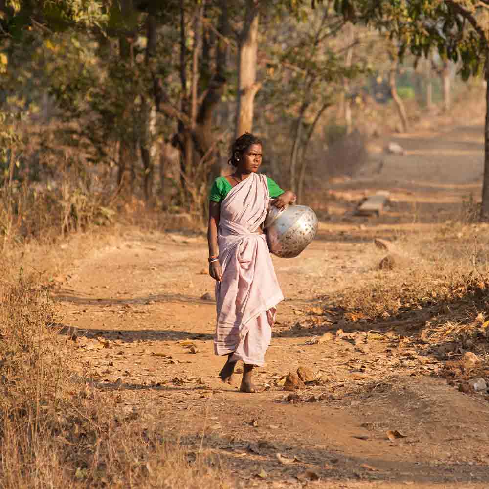 Woman walking long distances to acquire water due to severe water stress in her village