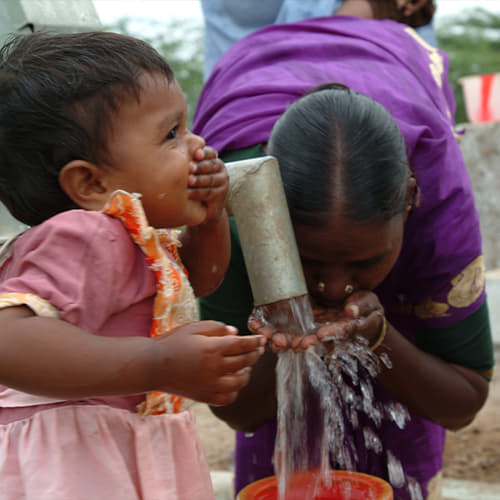 Woman and child drink clean water through GFA World Jesus Wells