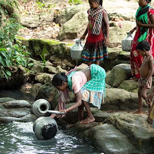 People from Garjan's village collect water from a contaminated open water source