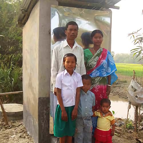 This family enjoys the benefits of sanitation through this gift of a GFA World outdoor toilet