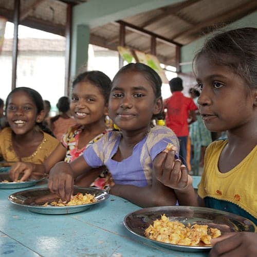 Children enjoying a nutritious meal through GFA World child sponsorship
