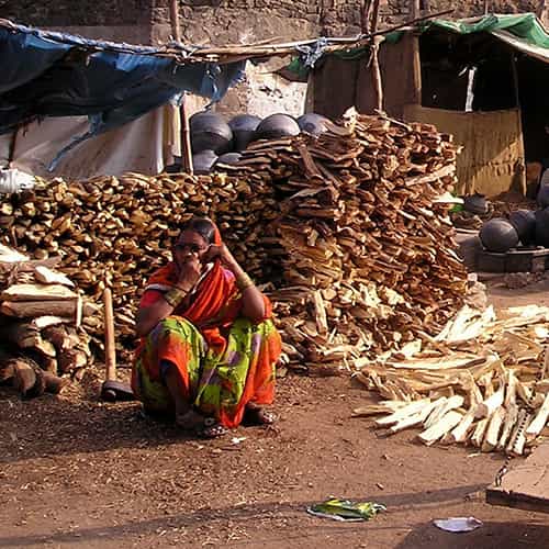 Woman in poverty from South Asia selling firewood