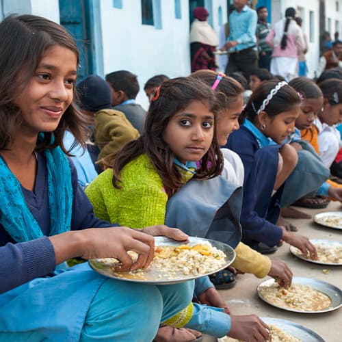 Girls enjoying nutritious meals from GFA World child sponsorship