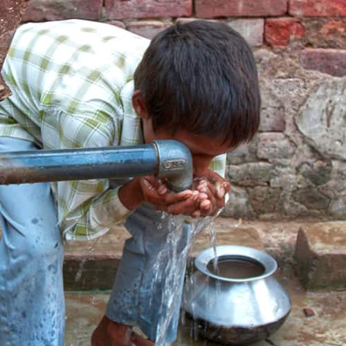 Young boy drinking clean water from GFA World Jesus Wells