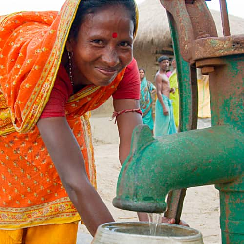 Woman drawing clean water from GFA World (Gospel for Asia) Jesus Wells