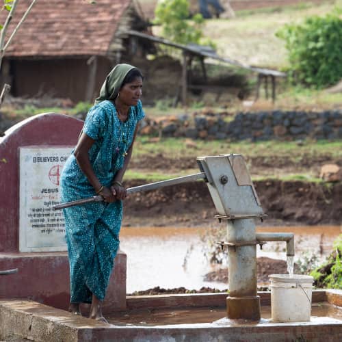 Woman collects clean water from GFA World (Gospel for Asia) Jesus Wells