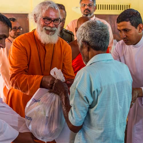 GFA World founder KP Yohannan with disaster relief team distributing relief supplies