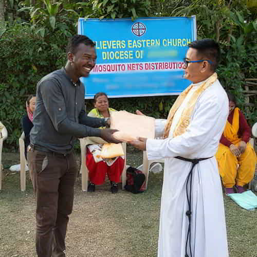 Pastor Kagan receives a mosquito net through GFA World gift distribution
