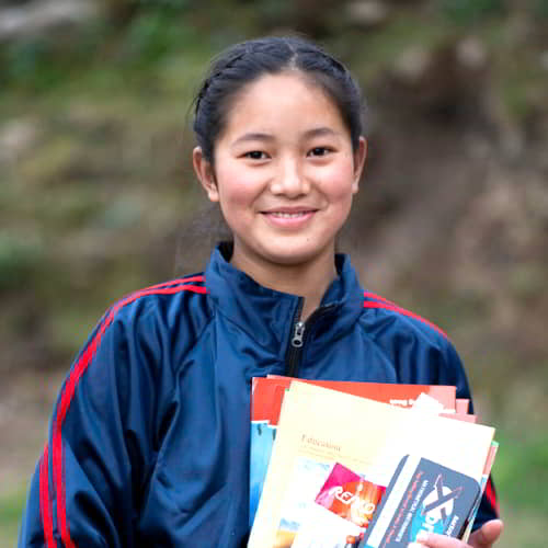 Young girl holding school supplies received from GFA World Child Sponsorship program