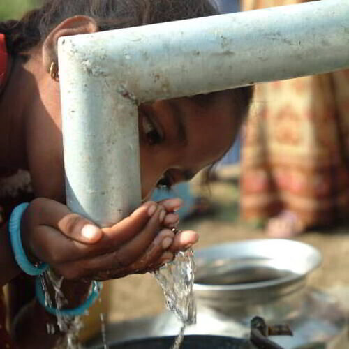 Young girl drinking clean water through GFA World Jesus Wells